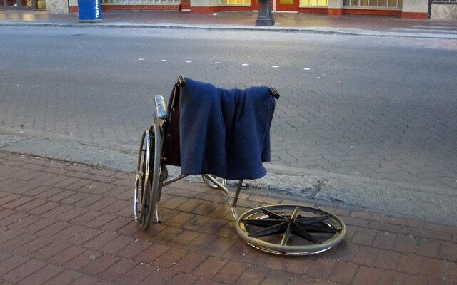 Tom och trasig rullstol på en trottoar